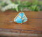 Raw Peruvian Opal Kintsugi ring with aqua blue stones and 18k gold plating on a wooden background.