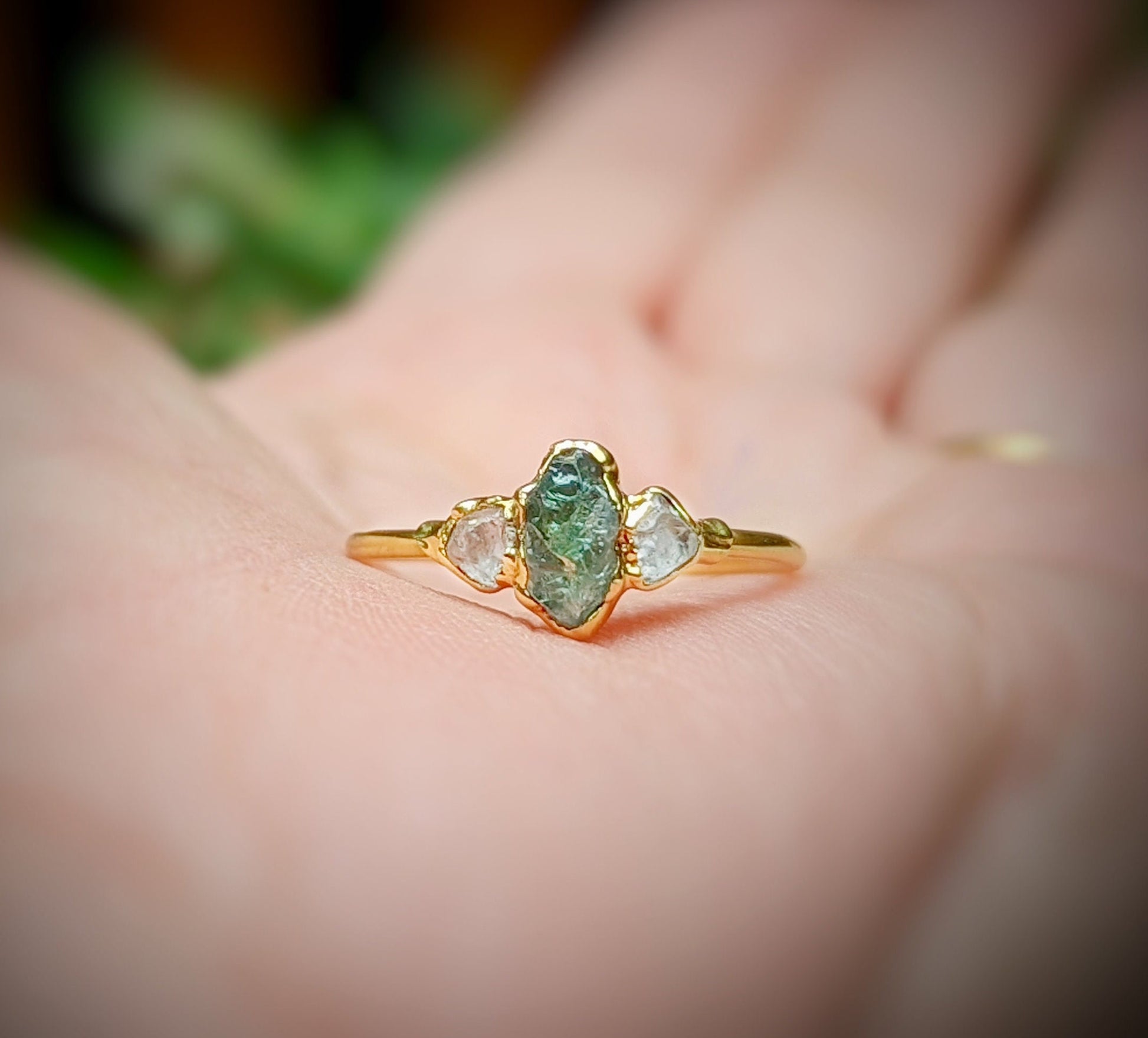 Raw green Sapphire and diamond engagement ring on a hand, crafted in 14k Gold, featuring natural gemstones.