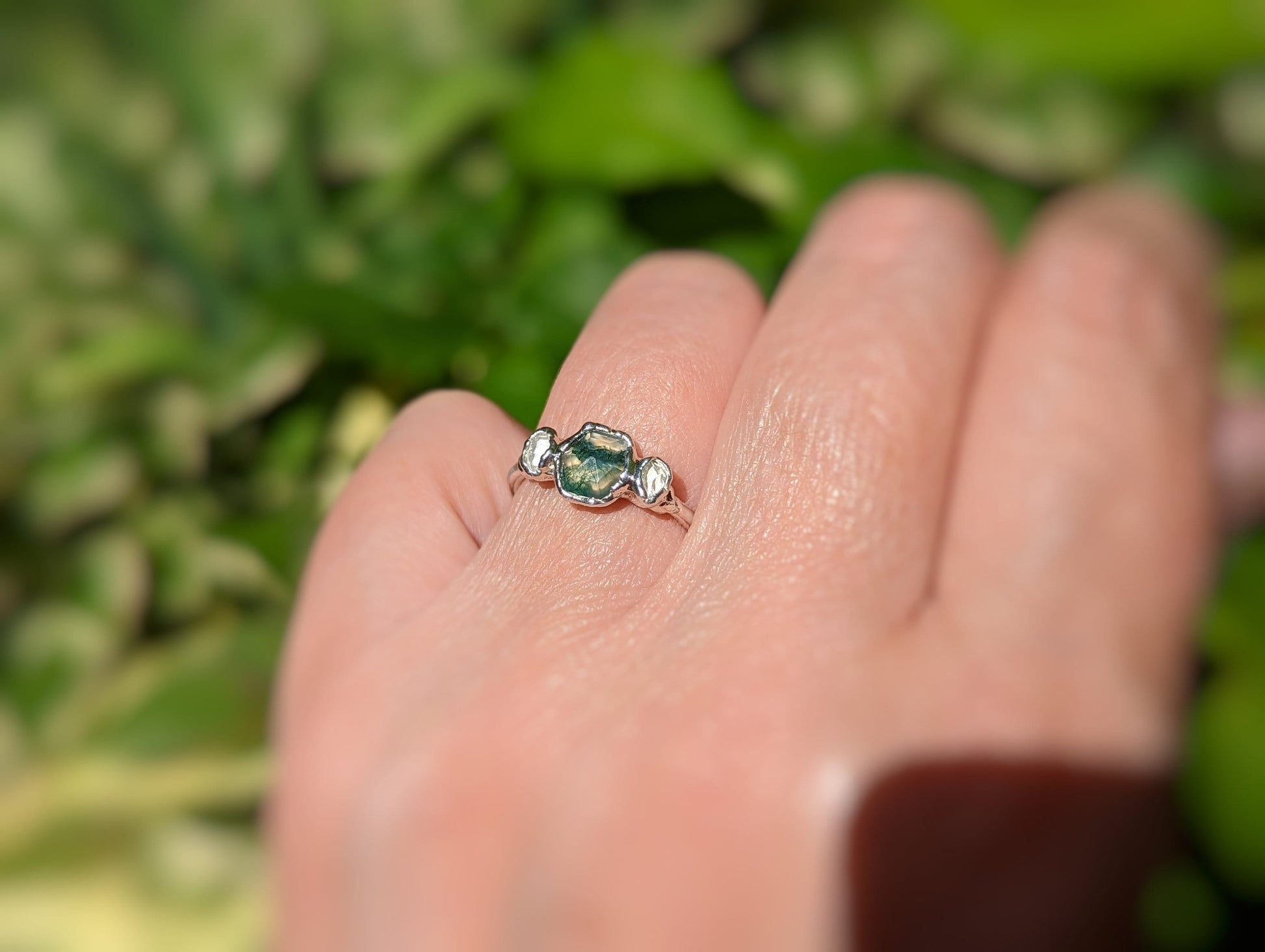 Handcrafted Moss Agate and Herkimer diamond engagement ring on a hand, showcasing natural beauty and rustic elegance.