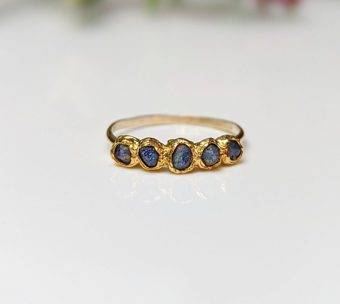 Raw sapphire multi-stone eternity ring on a solid 14k gold filled band, featuring small blue sapphires.