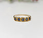 Raw sapphire multi-stone eternity ring on a solid 14k gold filled band, featuring small blue sapphires.