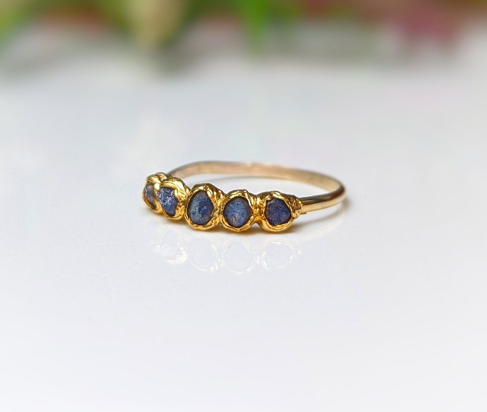 Raw sapphire multi-stone ring on solid 14k gold band, featuring 5-7 small blue sapphires, perfect for gifts and special occasions.
