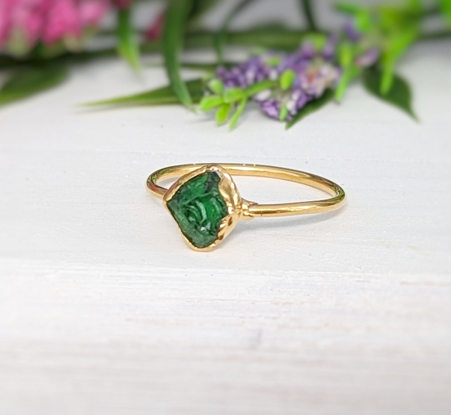 Handcrafted raw green Garnet ring with gold band, showcasing its natural beauty and uncut edges.