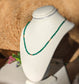 Emerald bead necklace on display, featuring green beads symbolizing love and friendship, ideal for gifting.