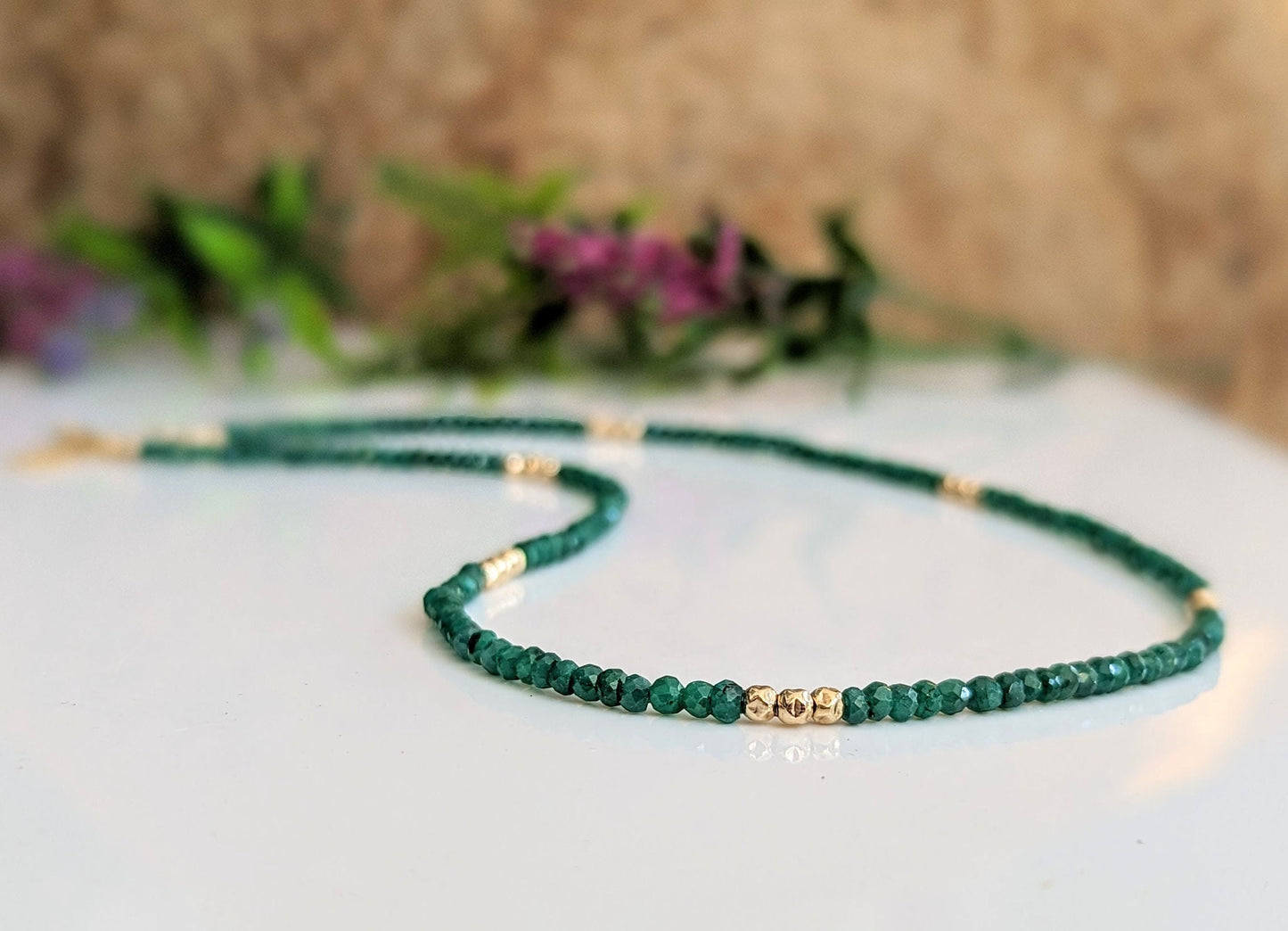 Emerald bead necklace with gold accents, symbolizing love and friendship, perfect for May birthdays.