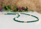 Emerald bead necklace with gold accents, symbolizing love and friendship, perfect for May birthdays.