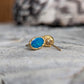 Elegant blue Australian opal stud earrings in 18k gold, showcasing unique craftsmanship and vibrant color.