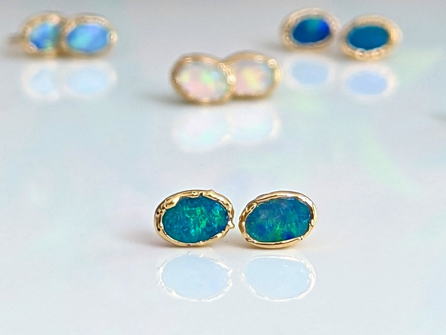 Blue Australian Opal stud earrings in 18k gold, showcasing elegance and handcrafted beauty, perfect for gifts.
