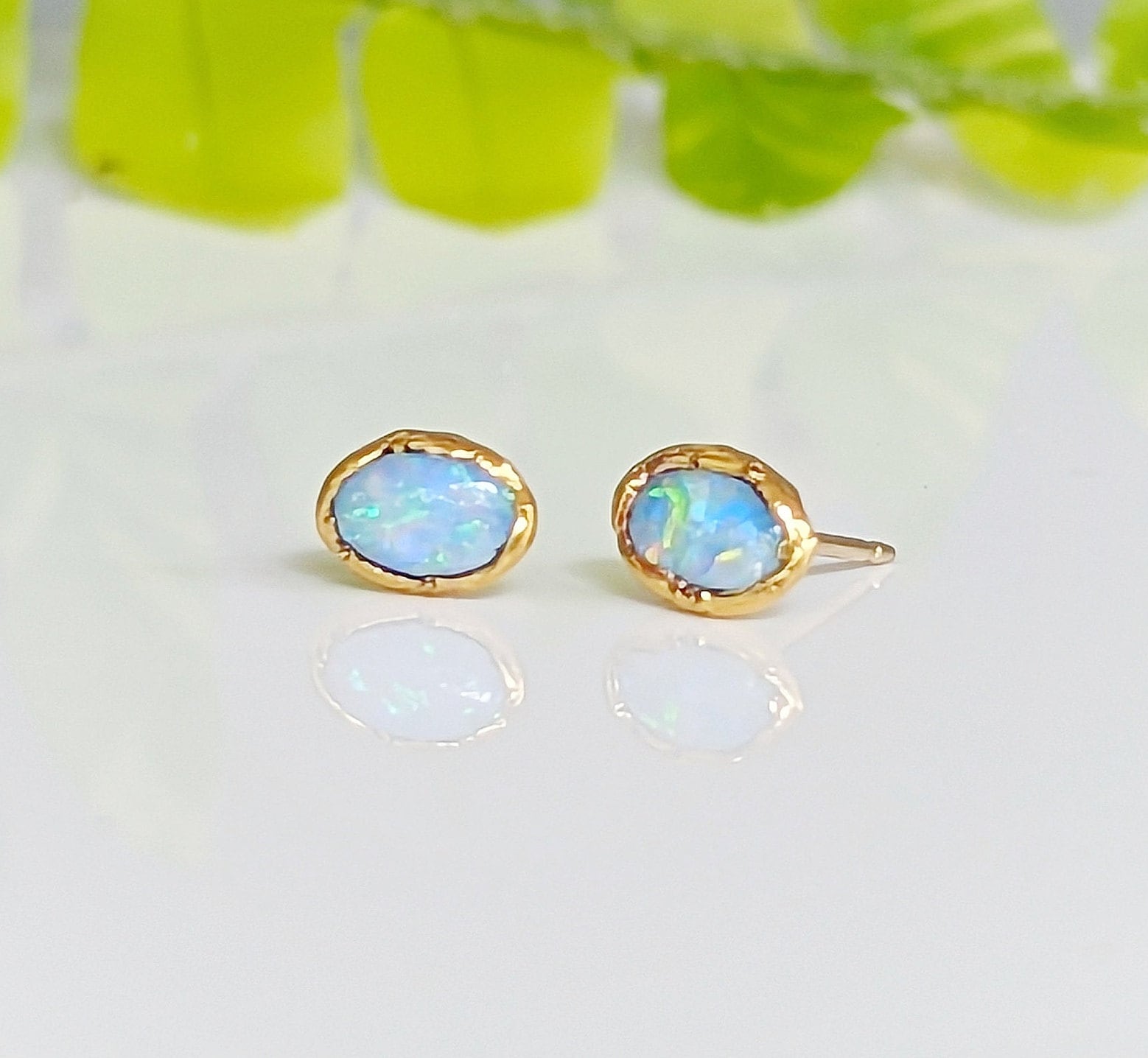Light blue Australian Opal stud earrings in gold settings, perfect for weddings and special occasions.