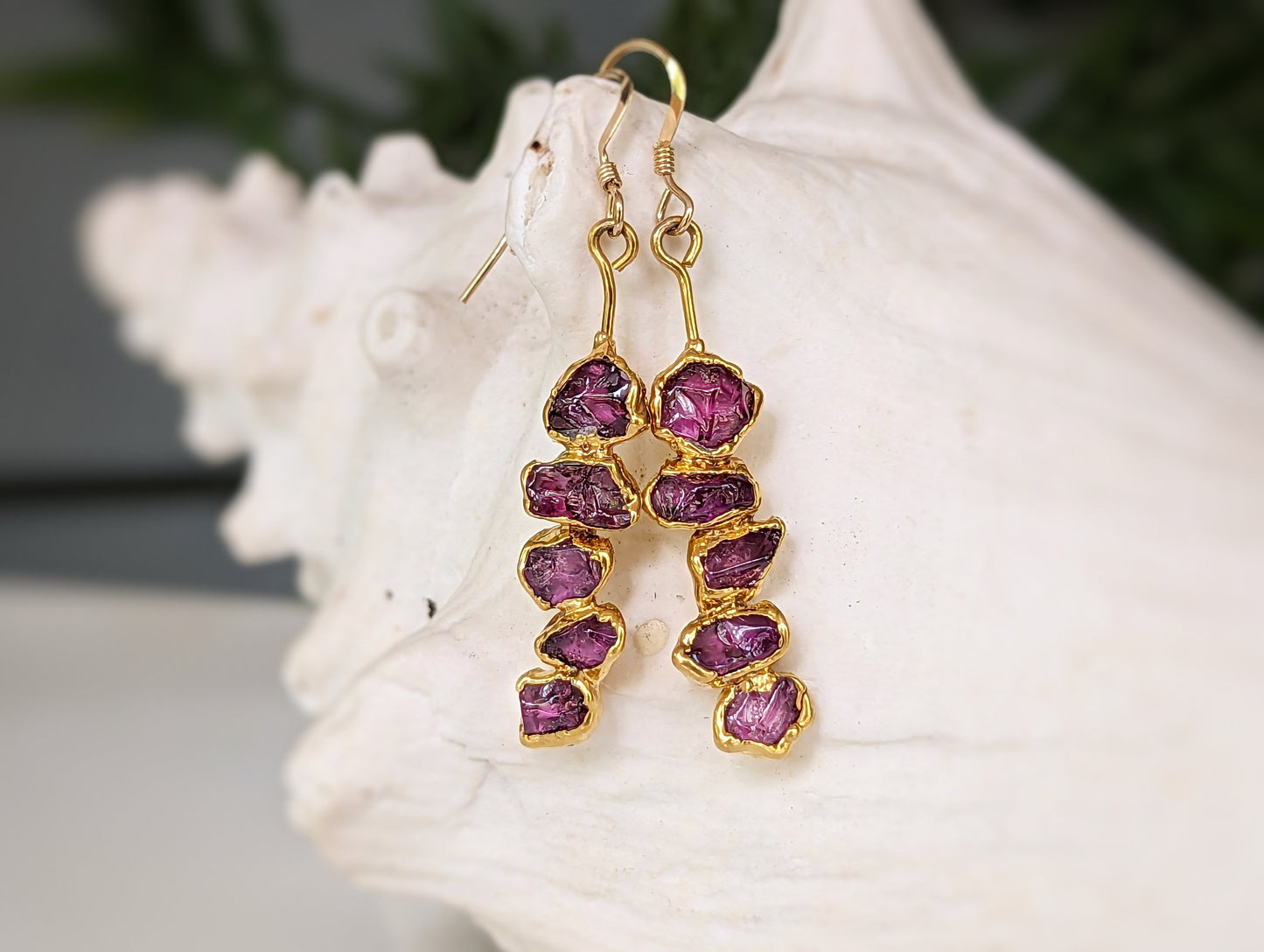 Rhodolite garnet dangle earrings with raw raspberry pink stones in a unique gold setting.
