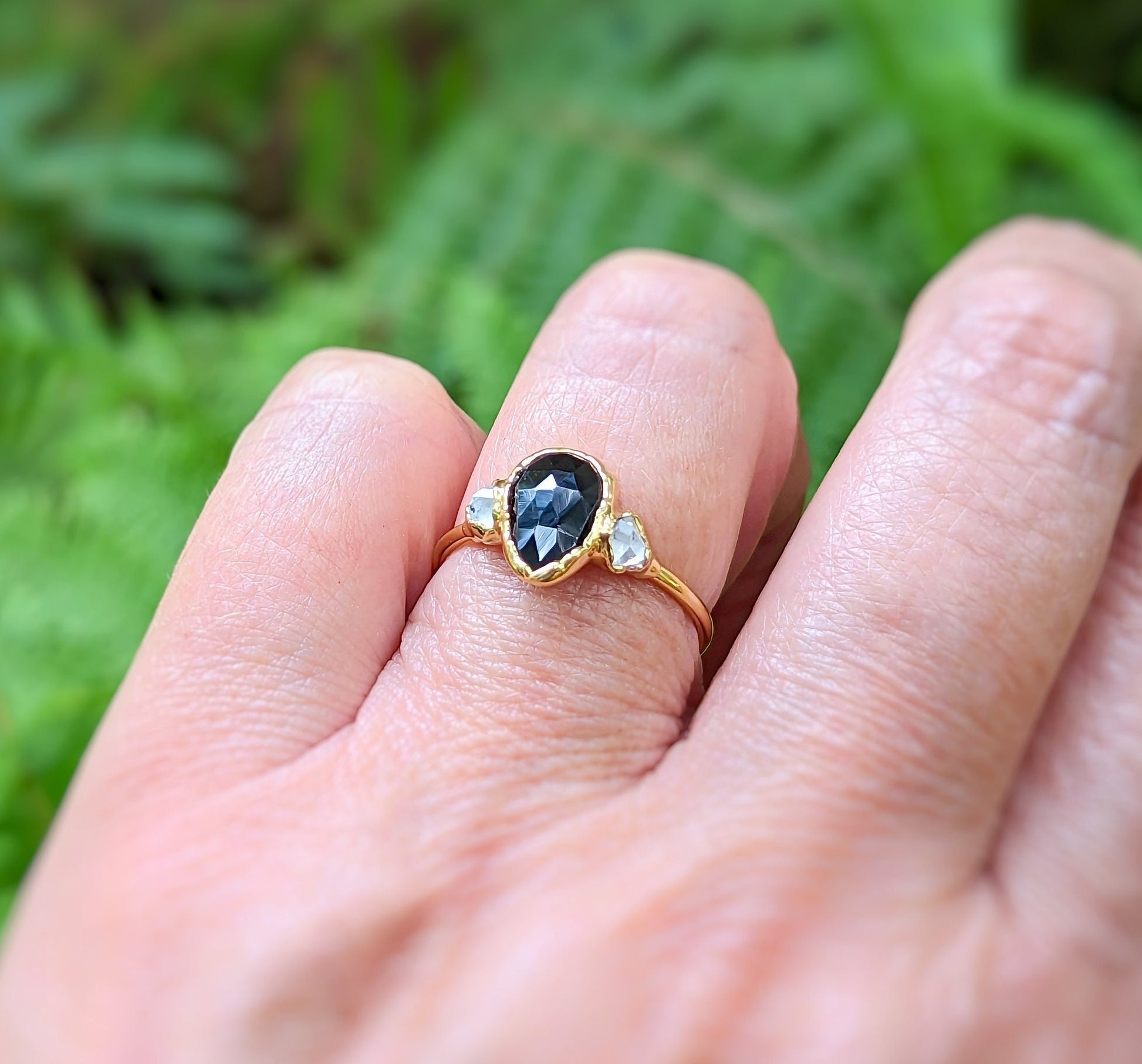 Black Spinel and Herkimer diamond engagement ring on hand, set in solid 18k gold, showcasing unique craftsmanship.