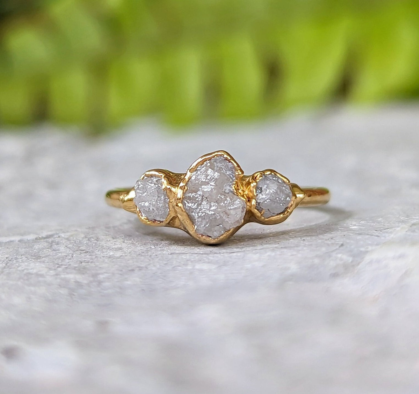 Handcrafted raw diamond engagement ring with three uncut diamonds on a solid gold band.