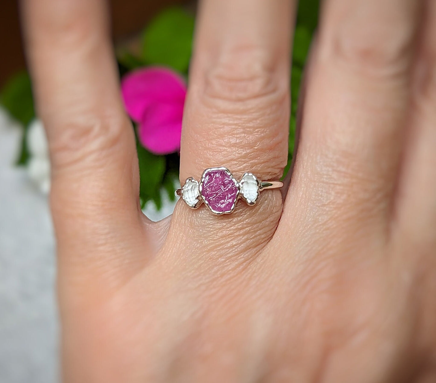 Raw pink Sapphire and Herkimer diamond engagement ring on a hand, perfect for nature lovers.