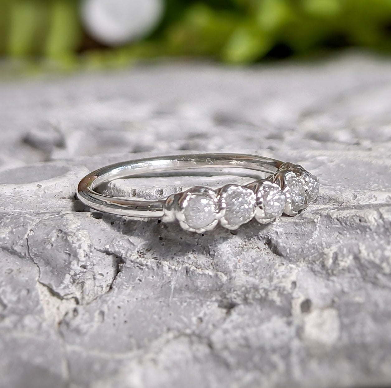 Raw diamond wedding band in silver featuring five conflict-free diamonds on a rustic sterling silver band.