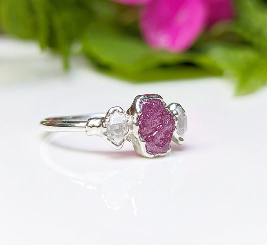 Raw pink Sapphire and Herkimer diamond engagement ring on a silver band, ideal for nature lovers.
