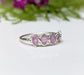Raw pink sapphire eternity ring on handcrafted sterling silver band, featuring 5-7 small raw sapphires.