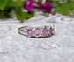 Raw pink sapphire eternity ring on a sterling silver band, perfect for gifts and special occasions.