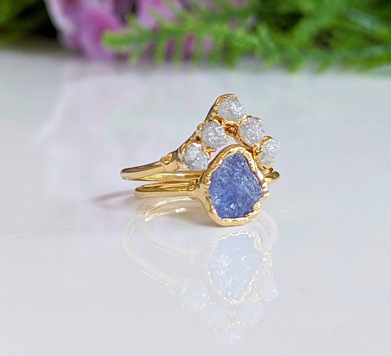 Raw Tanzanite and diamond Chevron wedding ring set on a gold band, featuring a stunning purple crystal design.