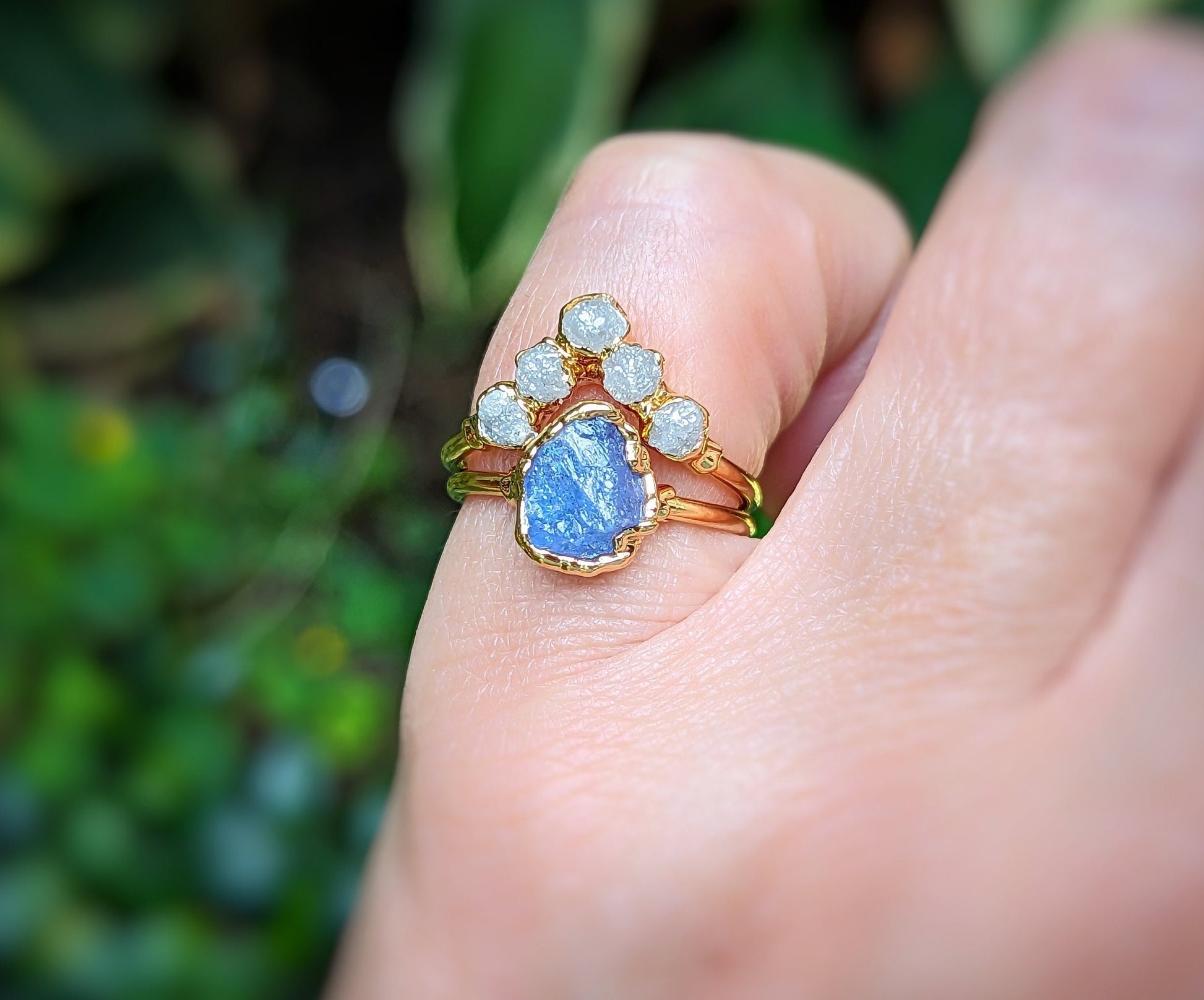 Raw Tanzanite and diamond Chevron wedding ring set on a hand, featuring a 14k gold band and unique design.