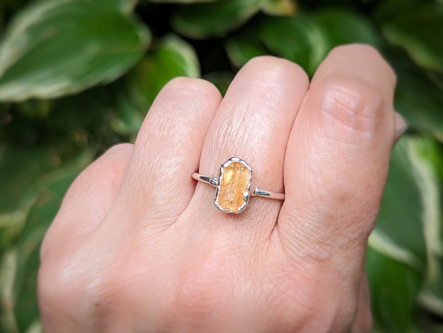 Hand wearing a handcrafted Sterling Silver ring featuring a raw Golden Imperial Topaz crystal, ideal for gifts.