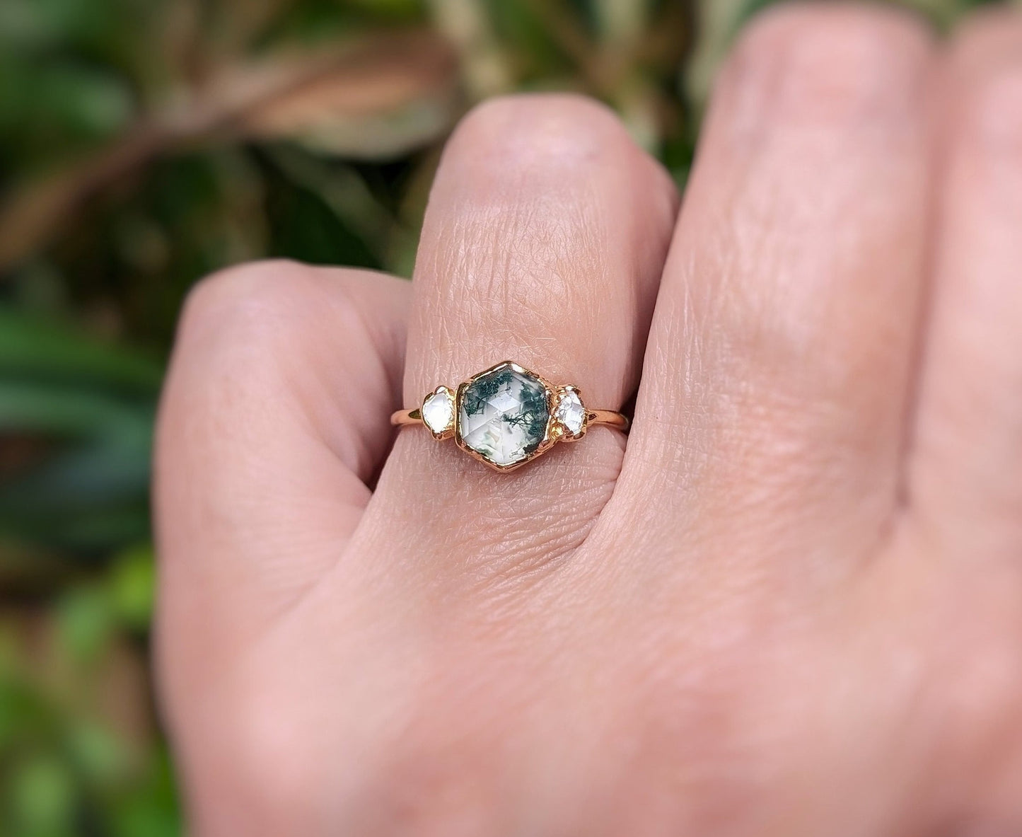 Moss Agate hexagon engagement ring with Herkimer diamonds on a hand, set in 14k gold.