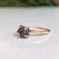 Raw black diamond engagement ring on solid 14k gold band showcasing a rustic and elegant design.