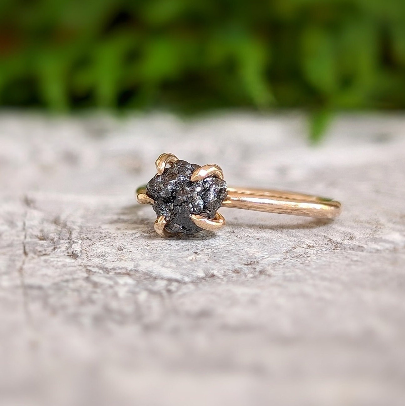 Raw black diamond engagement ring set on 14k gold band, showcasing rustic elegance and handcrafted detail.