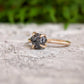 Raw black diamond engagement ring set on 14k gold band, showcasing rustic elegance and handcrafted detail.
