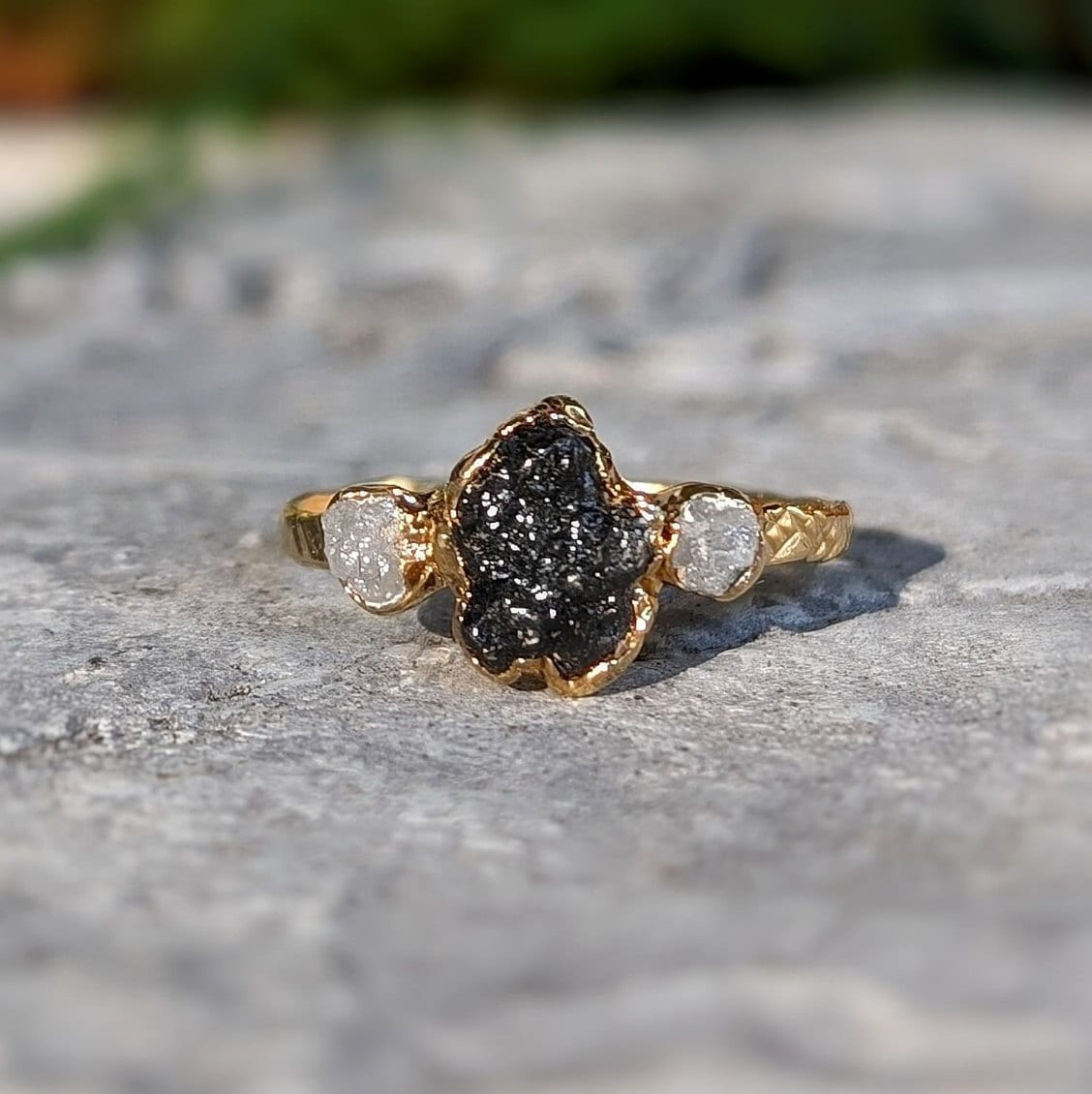 Handcrafted raw uncut Black Diamond engagement ring with solid 14k Gold band and two smaller raw diamonds.