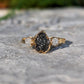 Handcrafted raw uncut Black Diamond engagement ring with solid 14k Gold band and two smaller raw diamonds.
