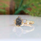 Raw uncut black diamond engagement ring on a solid 14k gold band, featuring two small raw diamonds.