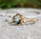 Moss Agate and Herkimer diamond engagement ring on a stone background, featuring a hexagon shape and 14k gold band.