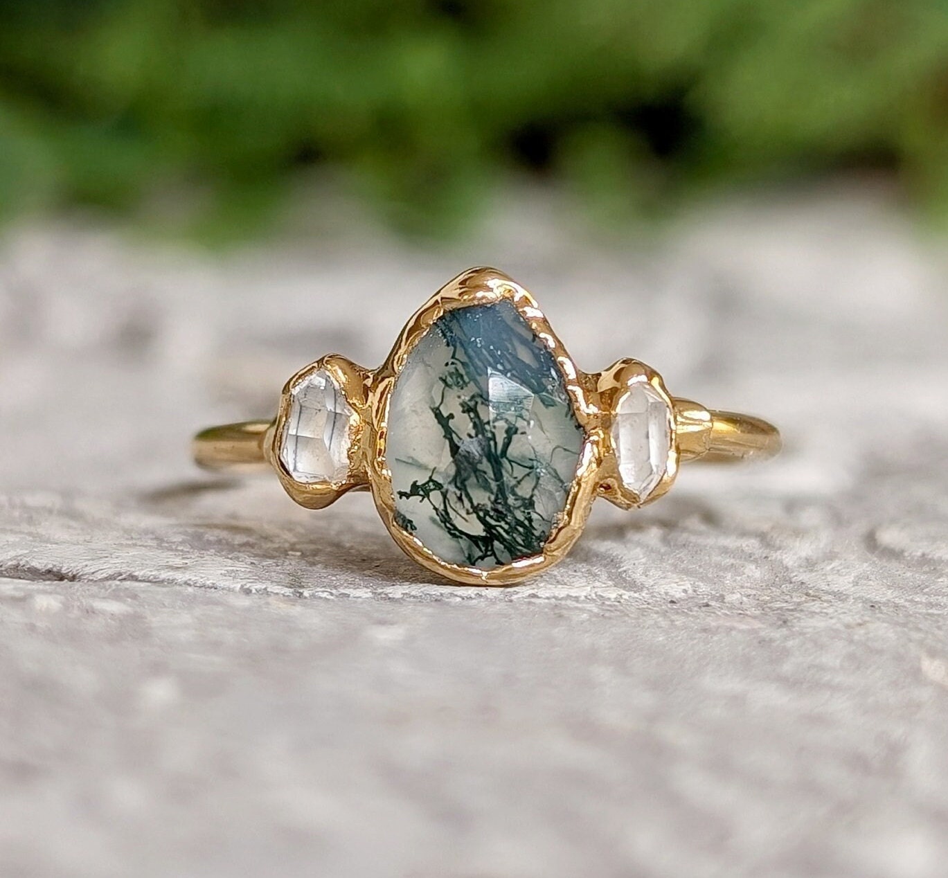 Moss Agate and Herkimer diamond engagement ring featuring a pear-shaped Moss Agate on a gold band.