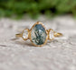 Moss Agate and Herkimer diamond engagement ring featuring a pear-shaped Moss Agate on a gold band.