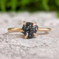 Raw black diamond engagement ring on a solid 14k gold band, featuring a unique rustic design.