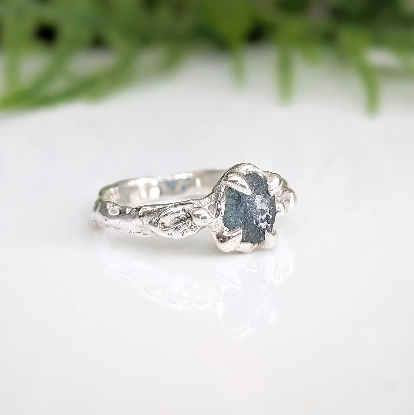 Raw Montana Sapphire ring in sterling silver with an organic molten band, showcasing teal blue-green hues.