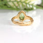 Handcrafted solid 14k gold peridot ring with organic textured band, capturing light beautifully.