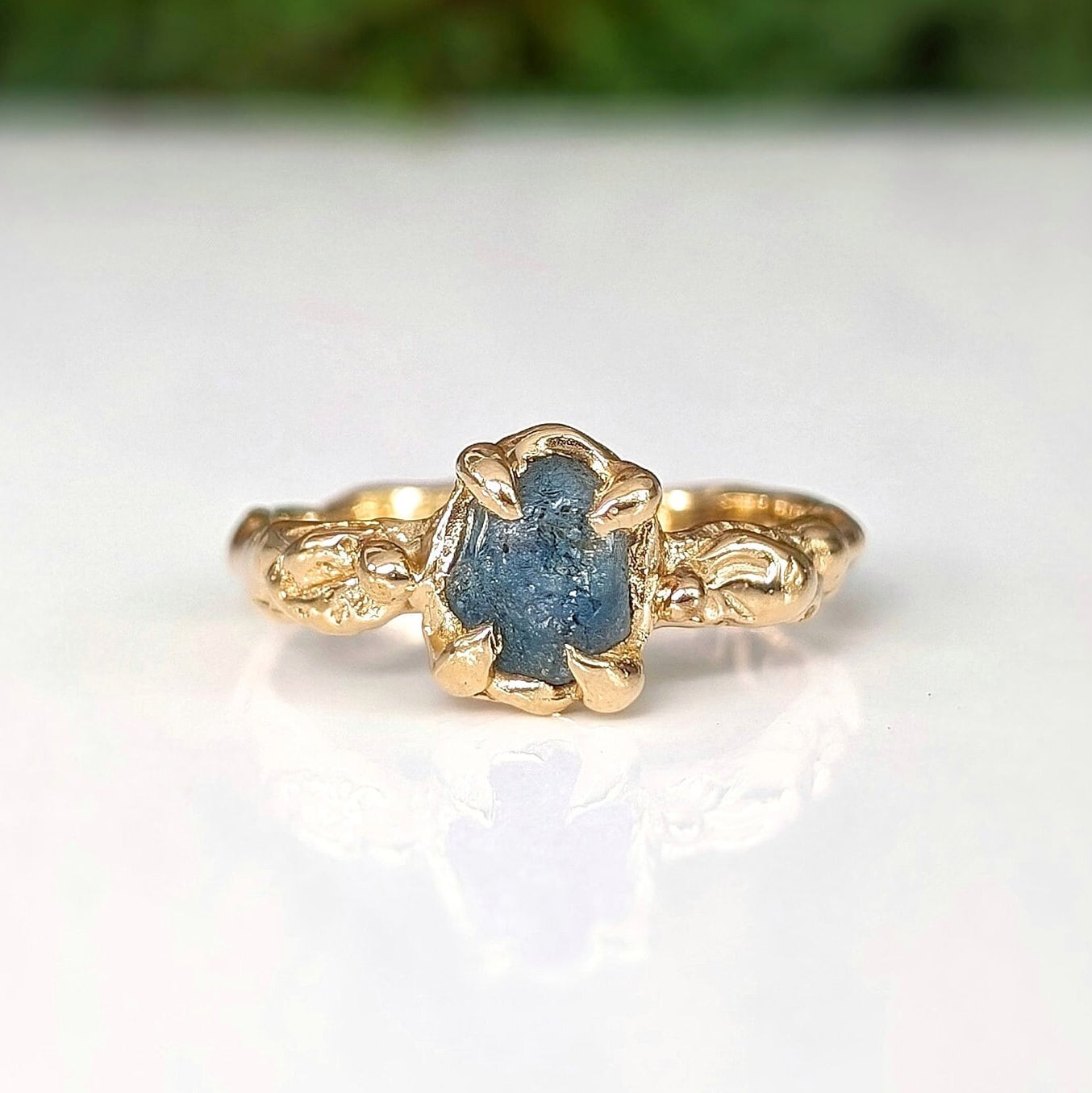 Raw Montana Sapphire engagement ring in solid 14k gold with organic textured band, showcasing natural elegance.