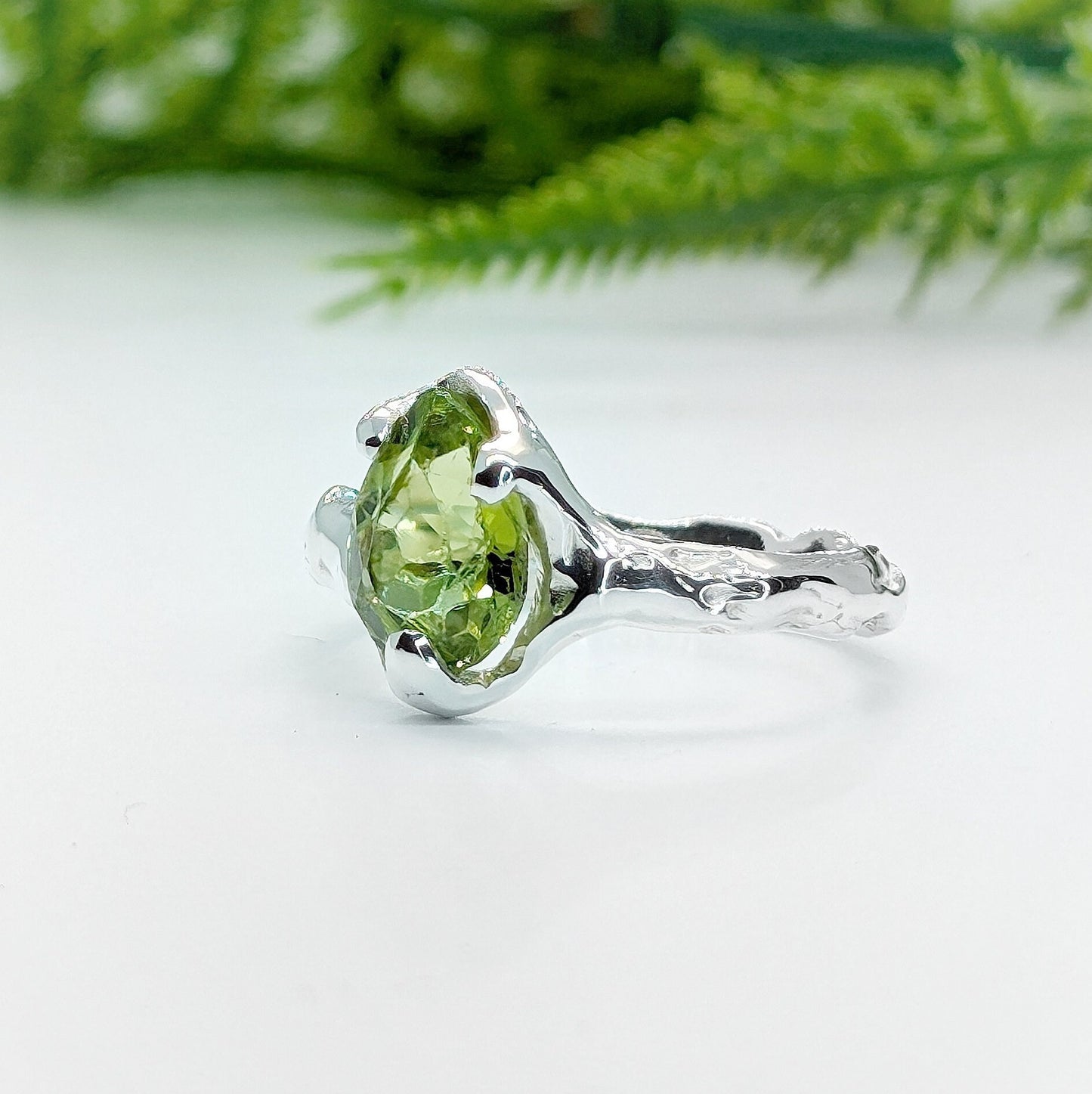 Handcrafted sterling silver ring featuring a stunning rose cut Peridot, showcasing a unique organic textured band.