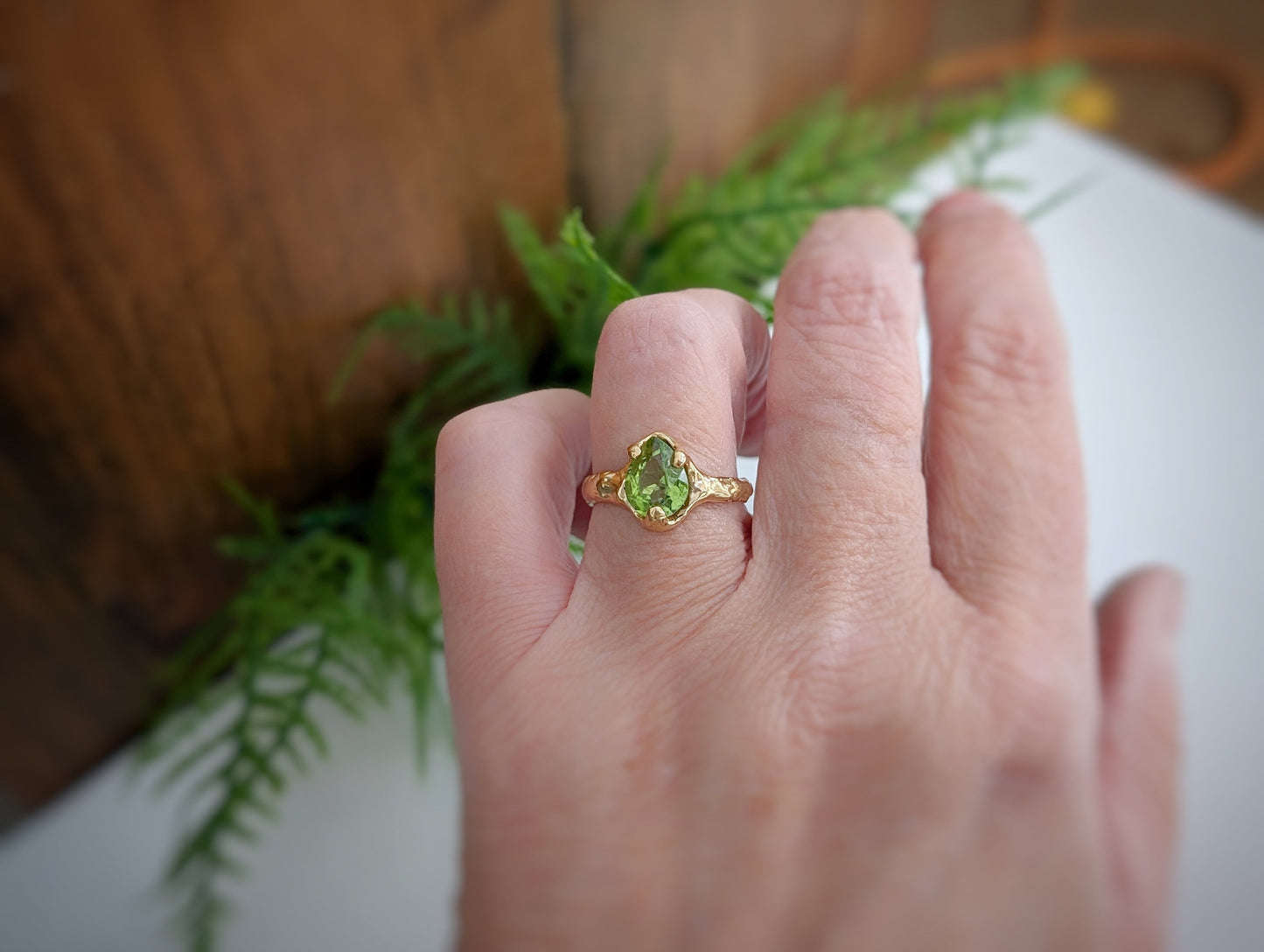 Handcrafted Peridot ring in solid 14k gold worn on hand, showcasing its unique design and green gemstone elegance.