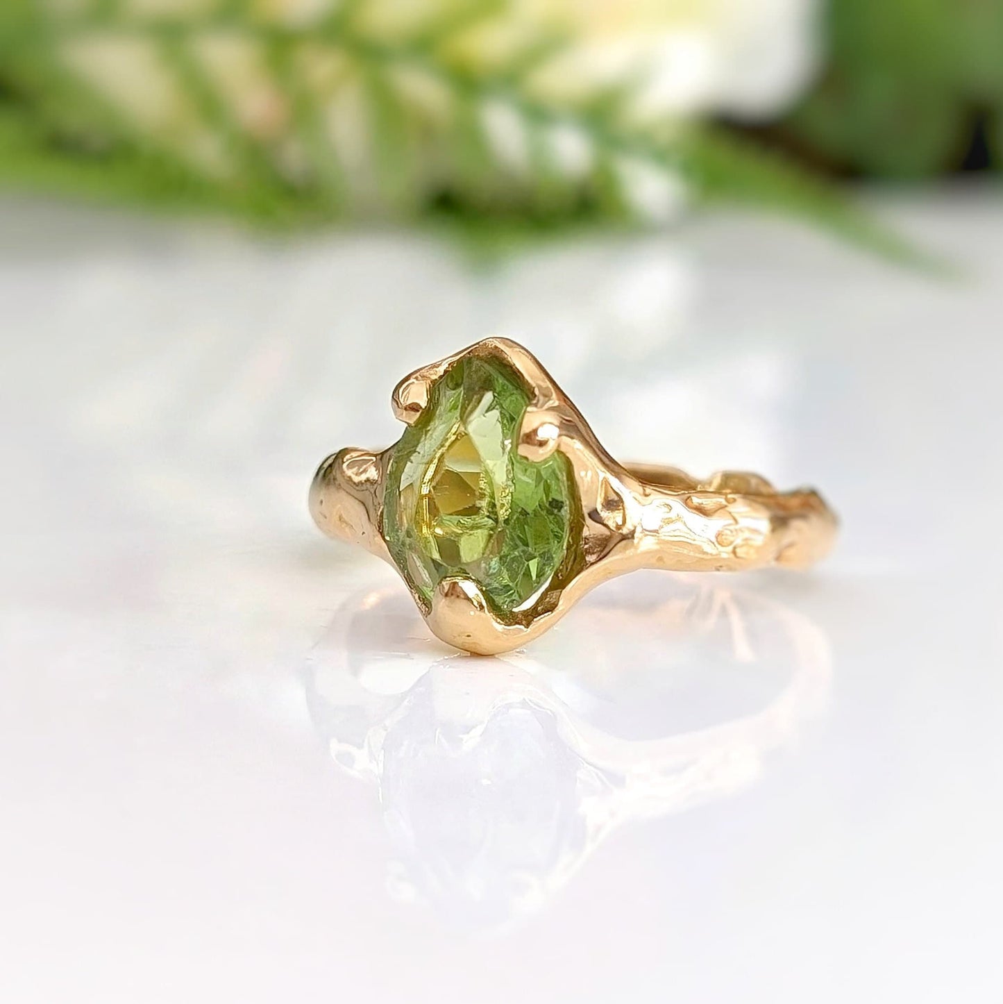 Handcrafted Peridot ring in solid 14k gold, featuring an organic textured band and a stunning green gemstone.