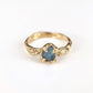 Raw Montana Sapphire engagement ring in solid 14k gold, featuring an organic textured band and unique teal stone.