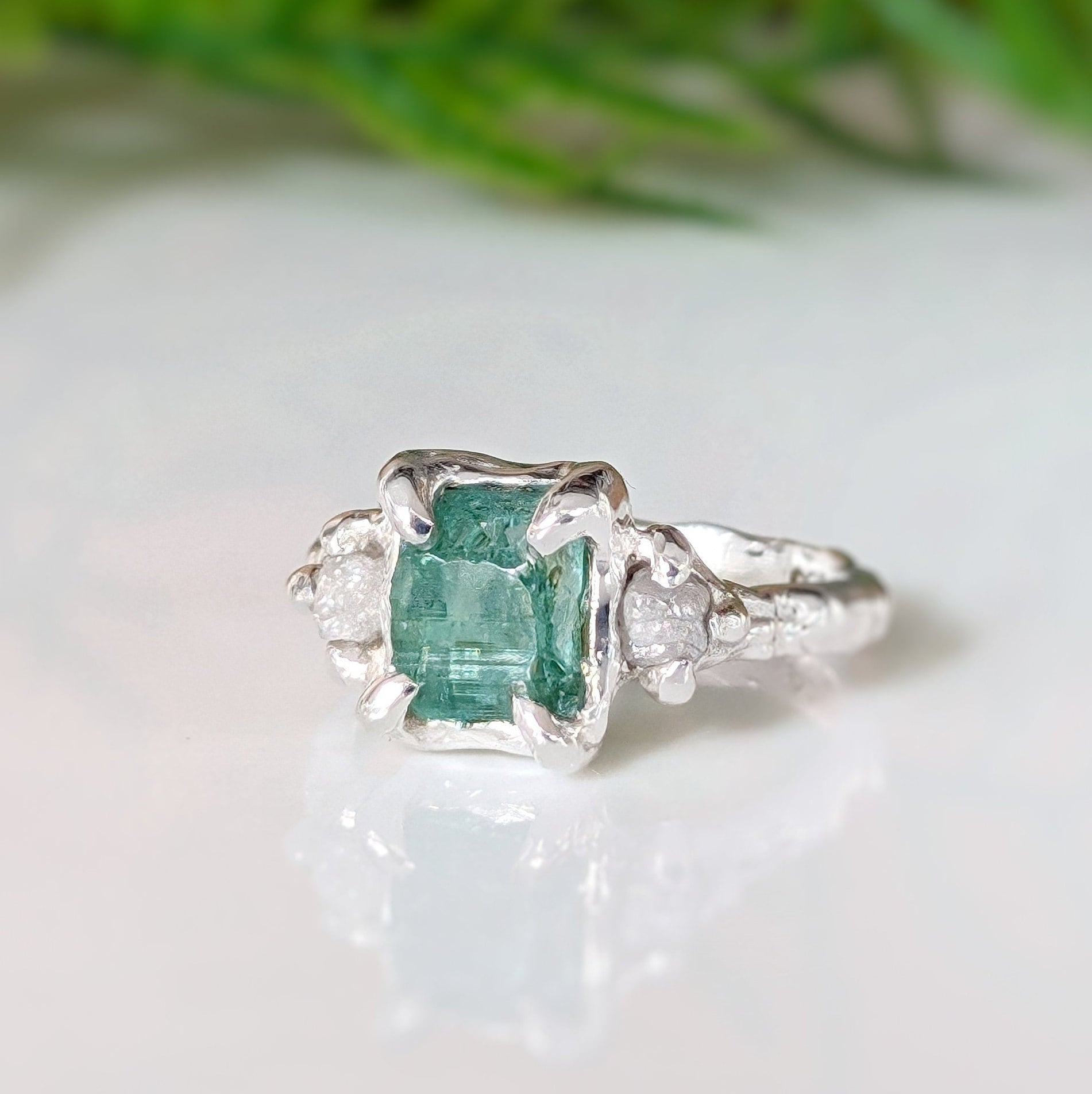 Raw emerald and diamond engagement ring in solid sterling silver with textured band and nature-inspired design.