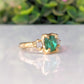 Raw emerald and diamond engagement ring in solid 14k gold, featuring a mint green emerald and two raw diamonds.