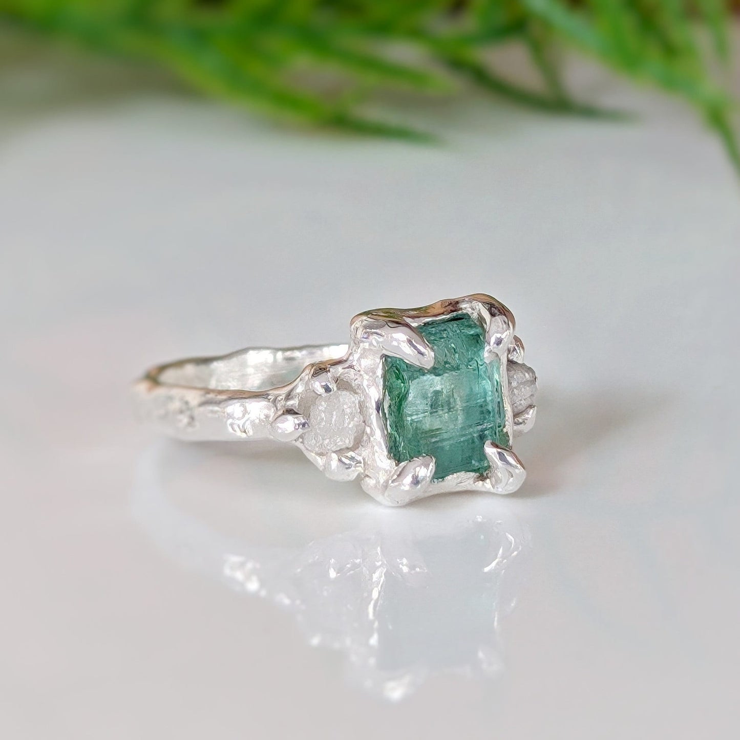 Raw emerald and diamond engagement ring in solid 14k gold, handcrafted with mint green emerald and two small raw diamonds.