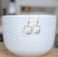 Keshi pearl square dangle earrings in gold-filled setting, displayed against a textured white ceramic bowl.