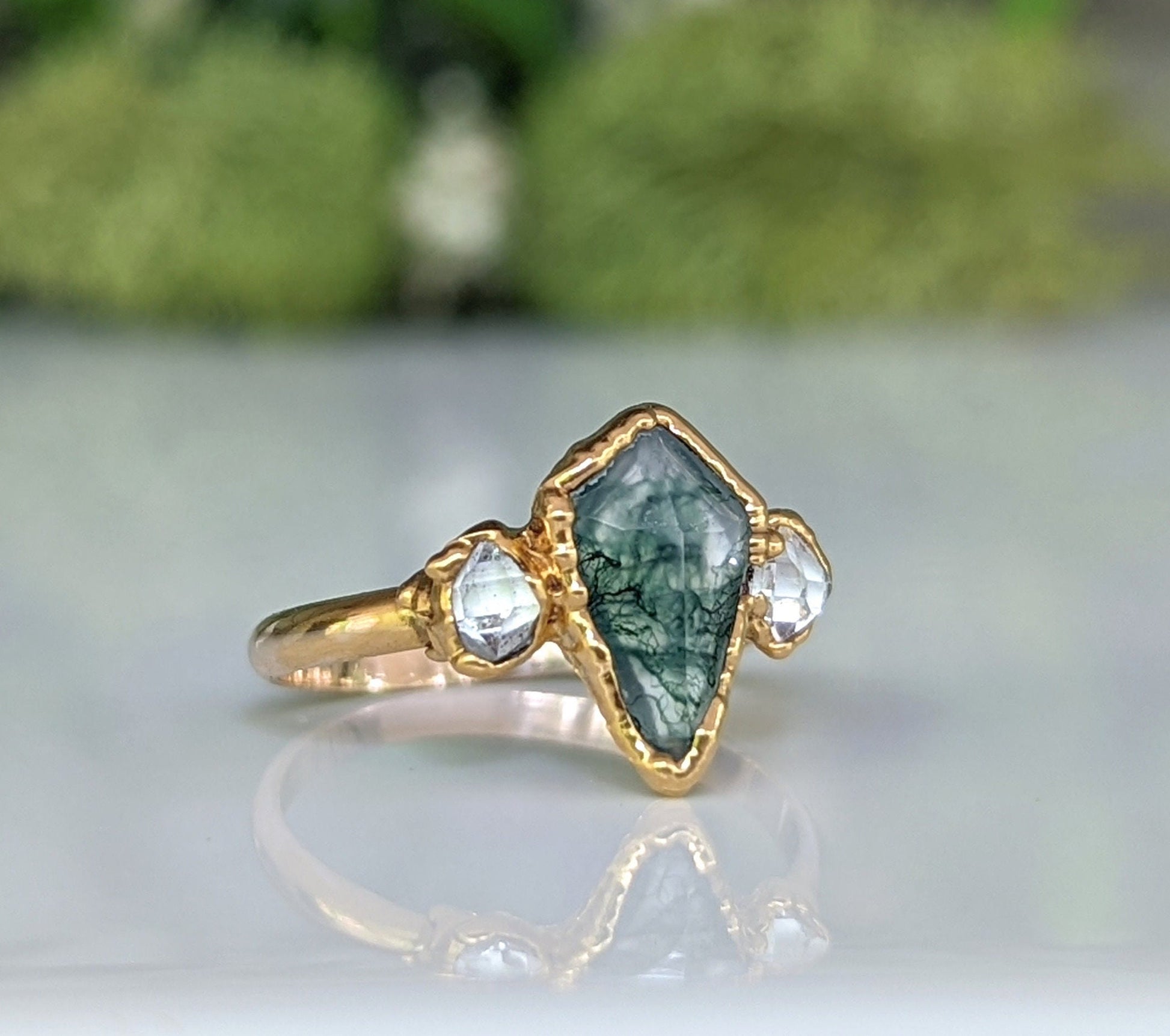 Kite-shaped Moss Agate and Herkimer diamond engagement ring with gold band, showcasing rustic elegance.