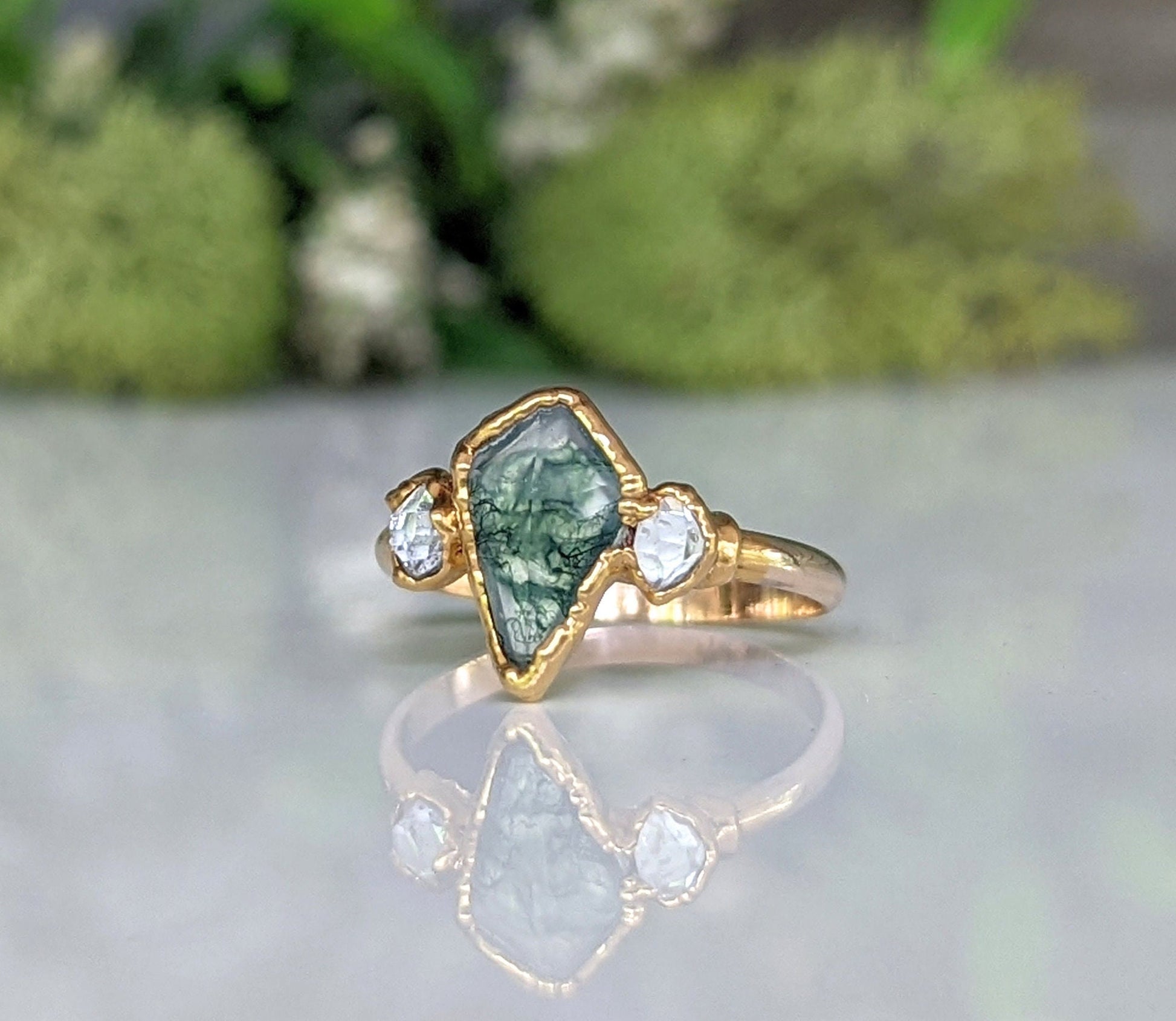 Kite-shaped Moss Agate and Herkimer diamond engagement ring with gold band, showcasing rustic elegance.