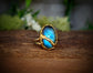 Labradorite Kintsugi ring featuring a blue stone set in a gold band, symbolizing beauty in restoration.