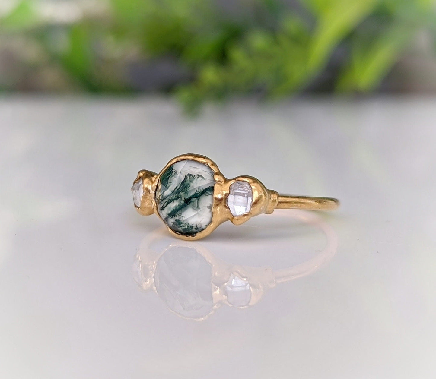 Moss Agate and Herkimer diamond engagement ring on a gold band, showcasing natural beauty and unique design.
